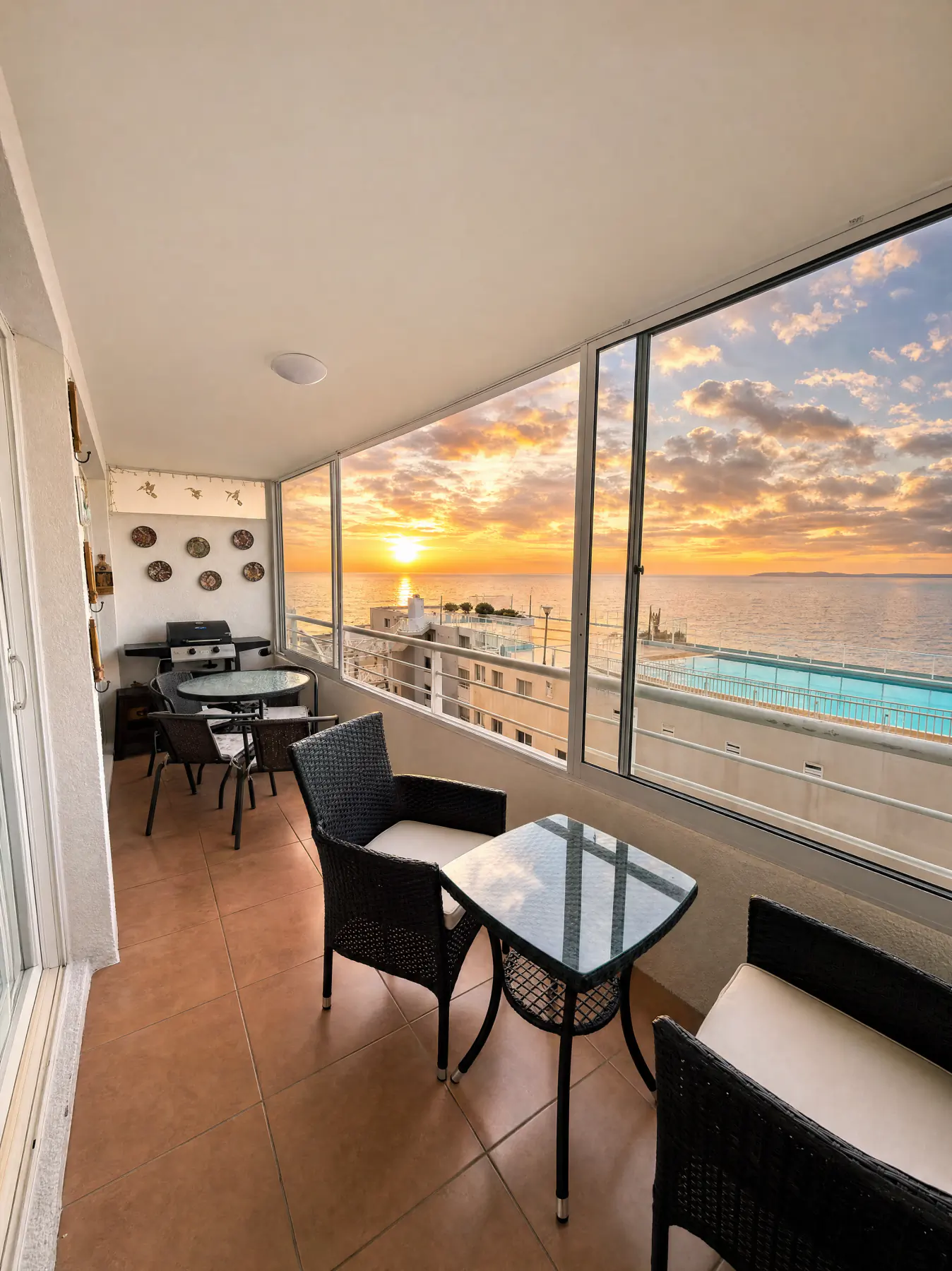 Terraza cerrada con vista al mar al atardecer y a la piscina del condominio, Costas de Montemar, Concón