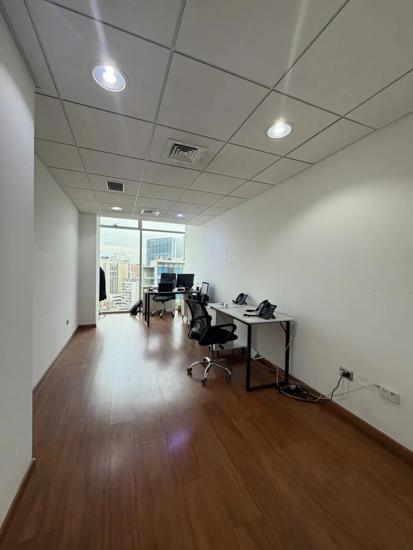 Oficina luminosa con estaciones de trabajo junto al ventanal