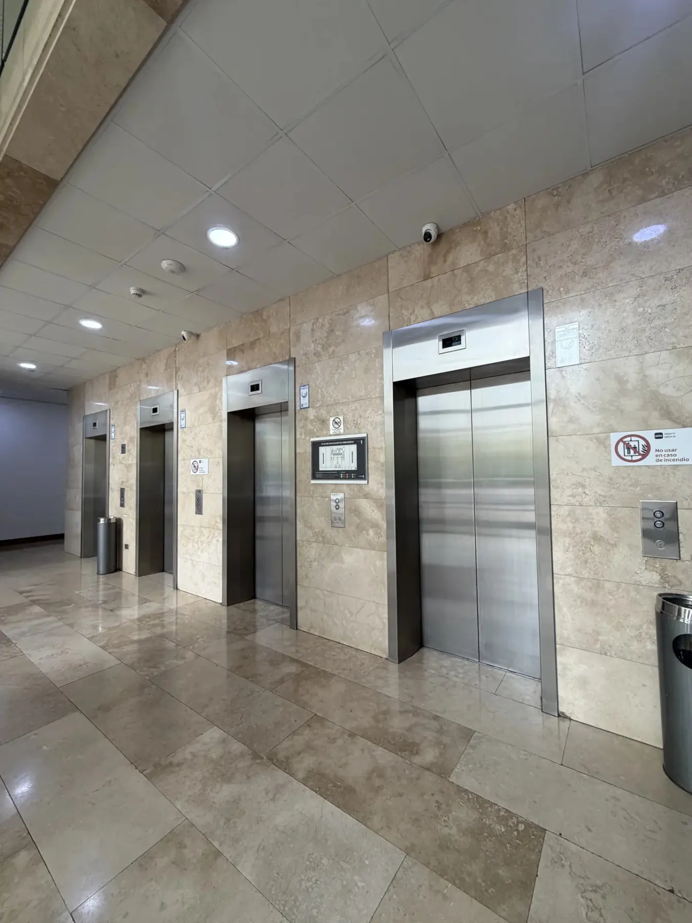 Hall de ascensores del edificio con revestimiento de piedra