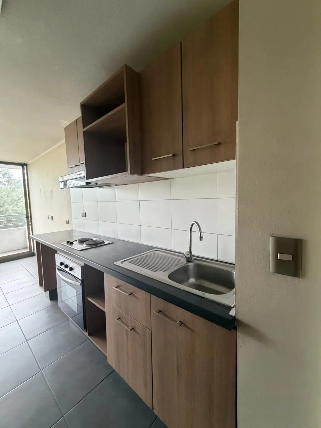 Cocina con encimera eléctrica, lavaplatos y muebles altos y bajos